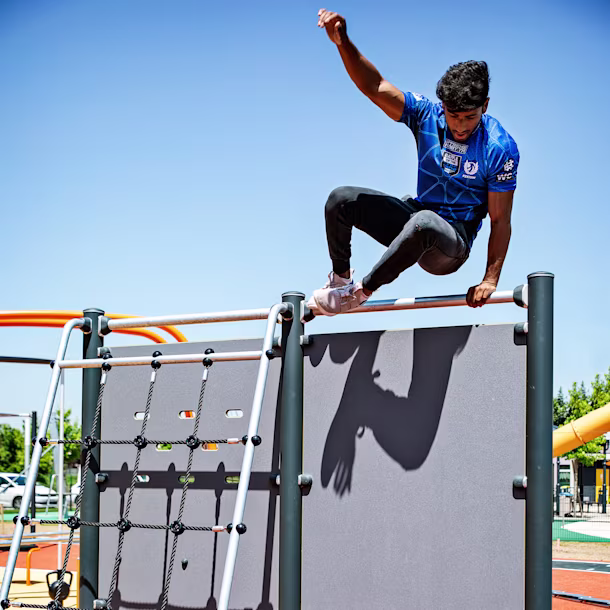 homme escaladant un filet vertical sur une course d'obstacles en plein air