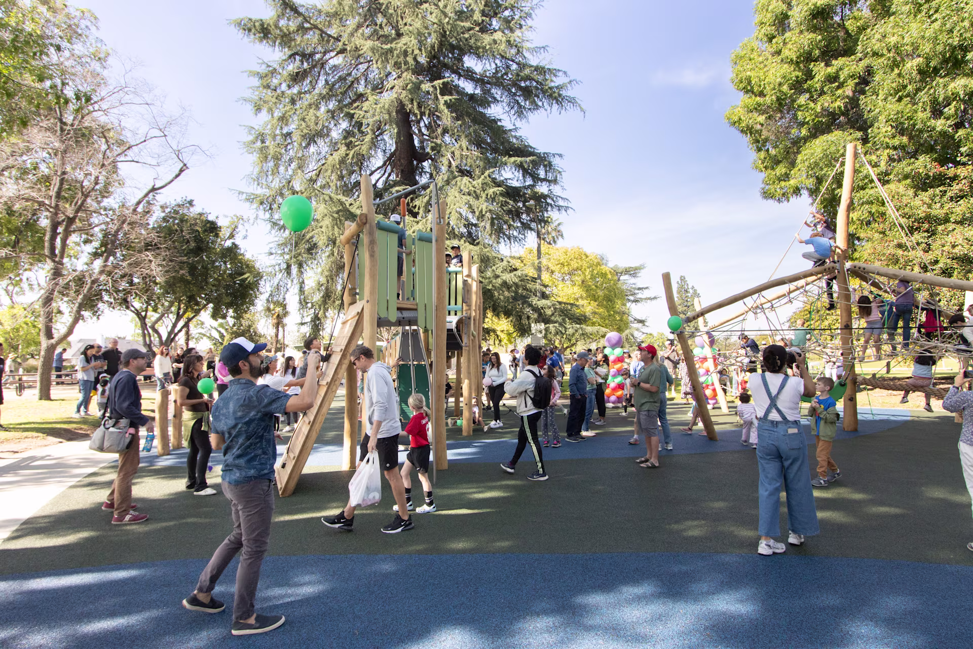 Large, wooden playground climbing towers and domes at Lewis Park's playground opening in Claremont, California