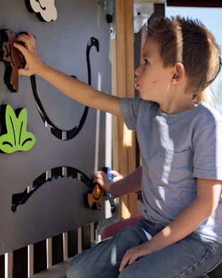 boy playing on play panels on a robinia infinity sculpture