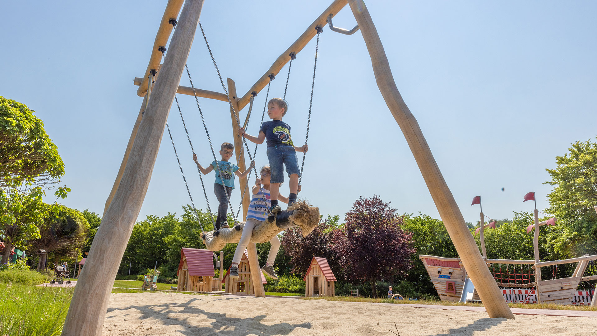 Kinder schaukeln auf einer Kokoswellen-Schaukel aus Robinienholz in Alfeld, Deutschland