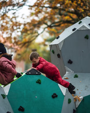 un garçon et une fille grimpant sur des blocs d'escalade d'une aire de jeux