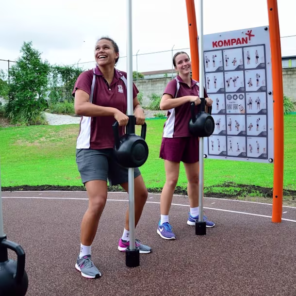 Secondary school students using KOMPAN strength training outdoor gym equipment