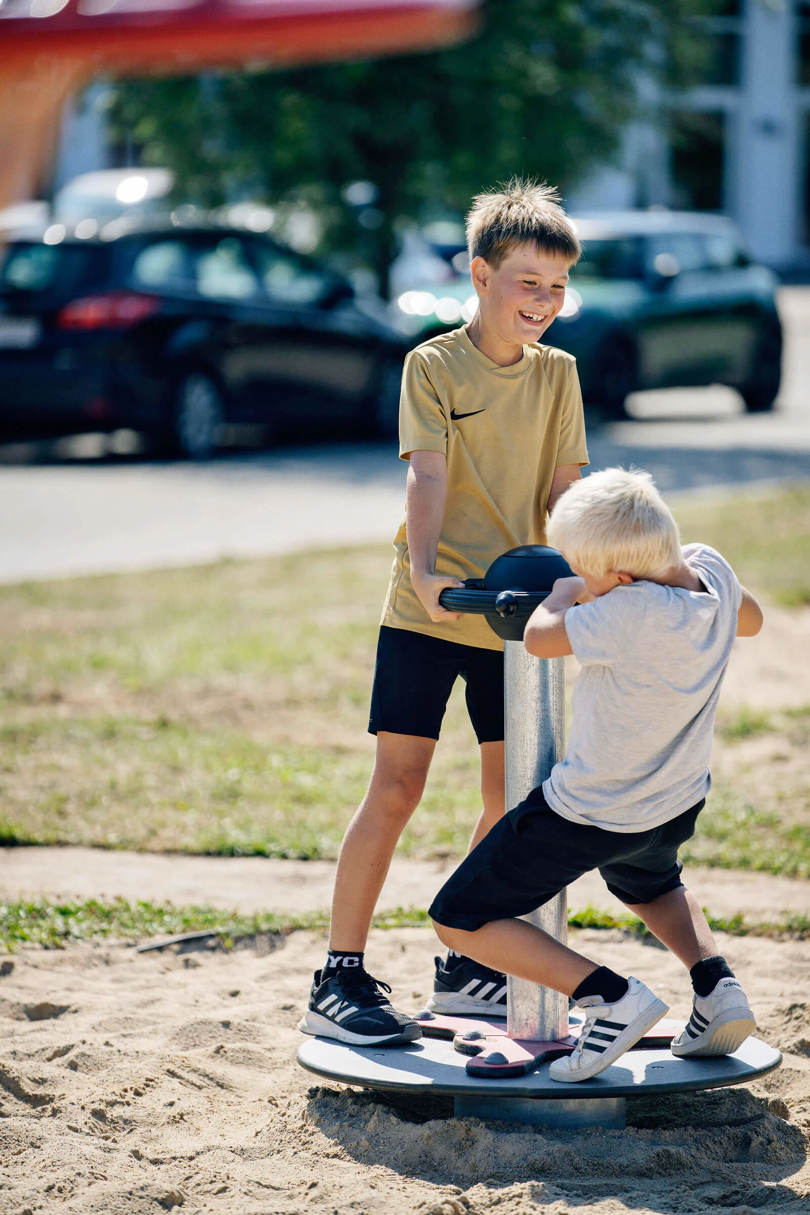 Two boys playing on the scooter carousel