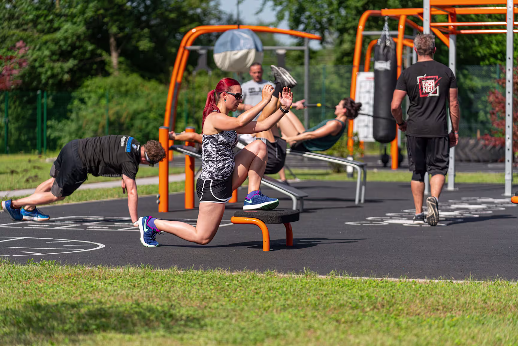 People working out on calisthenics and functional outdoor training systems