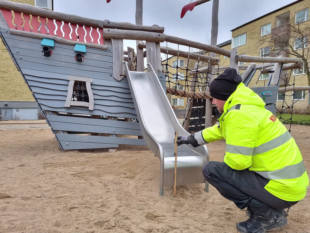 två flickor klättrar på lekredskap i en park