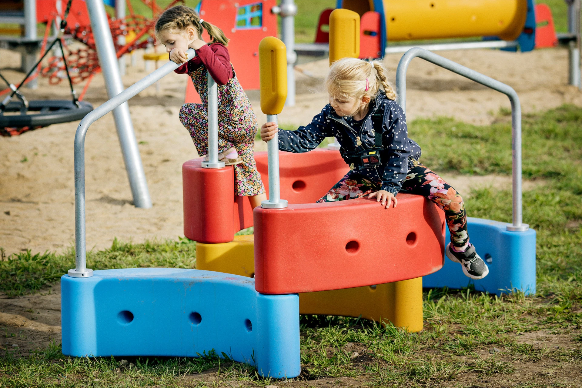 two girl climbing on playground equipment in a park