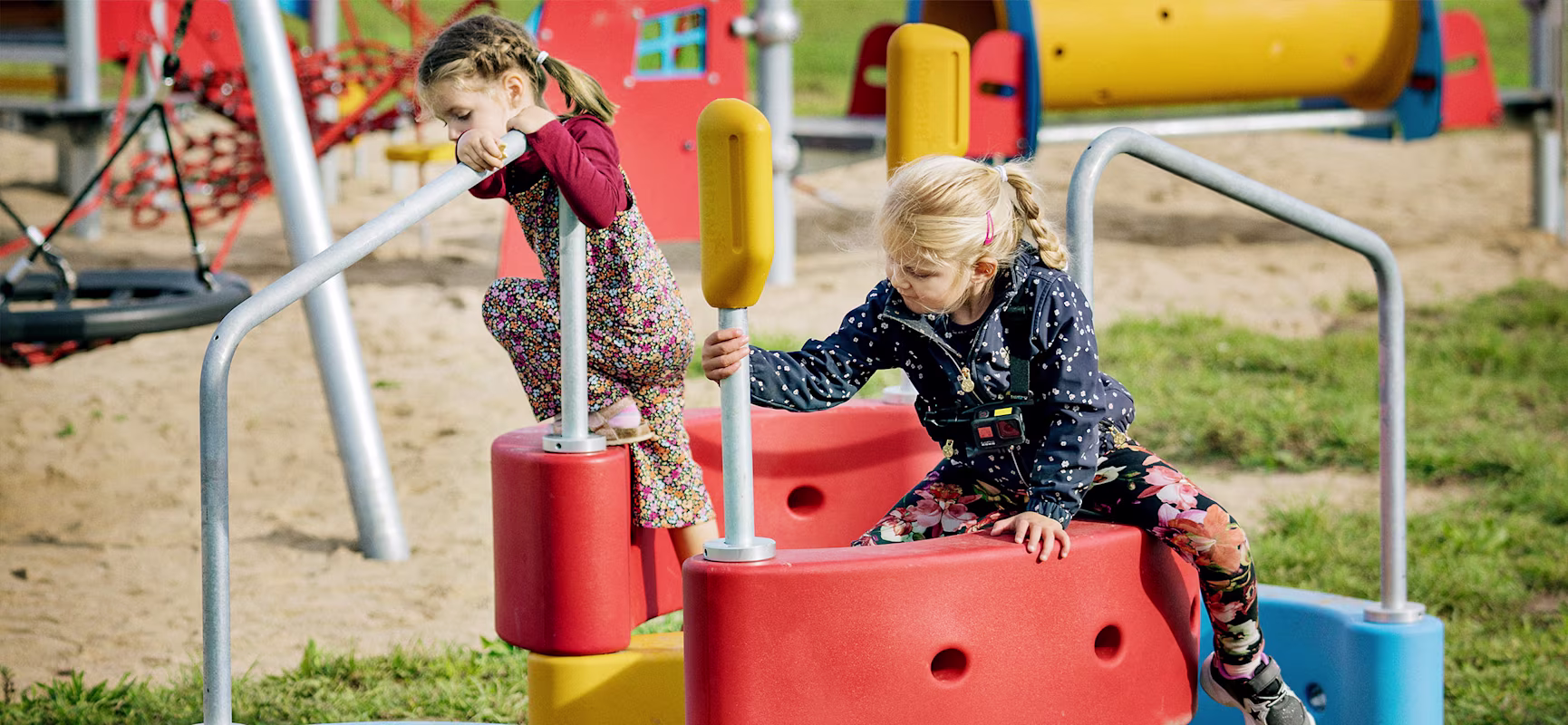 two girl climbing on playground equipment in a park