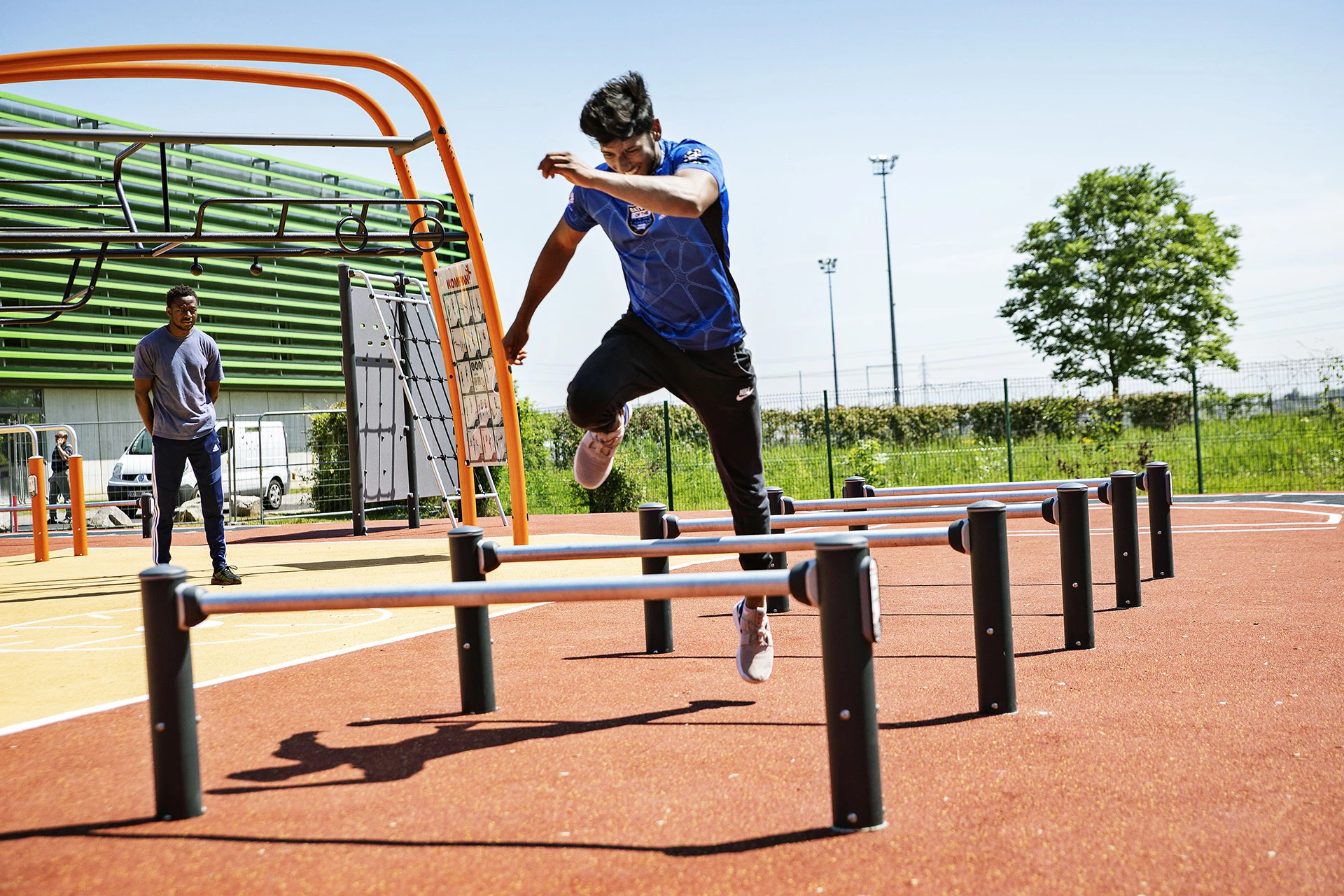 man jumping over hurdles on an outdoor obstacle  course
