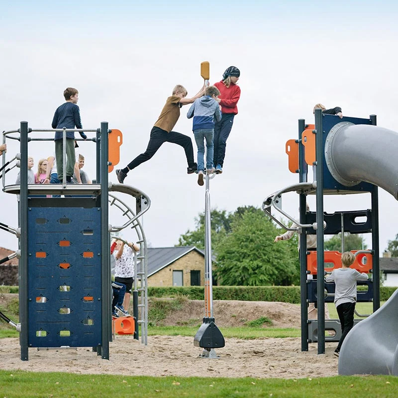 school agers playing on thrilling play tower in schoolyard
