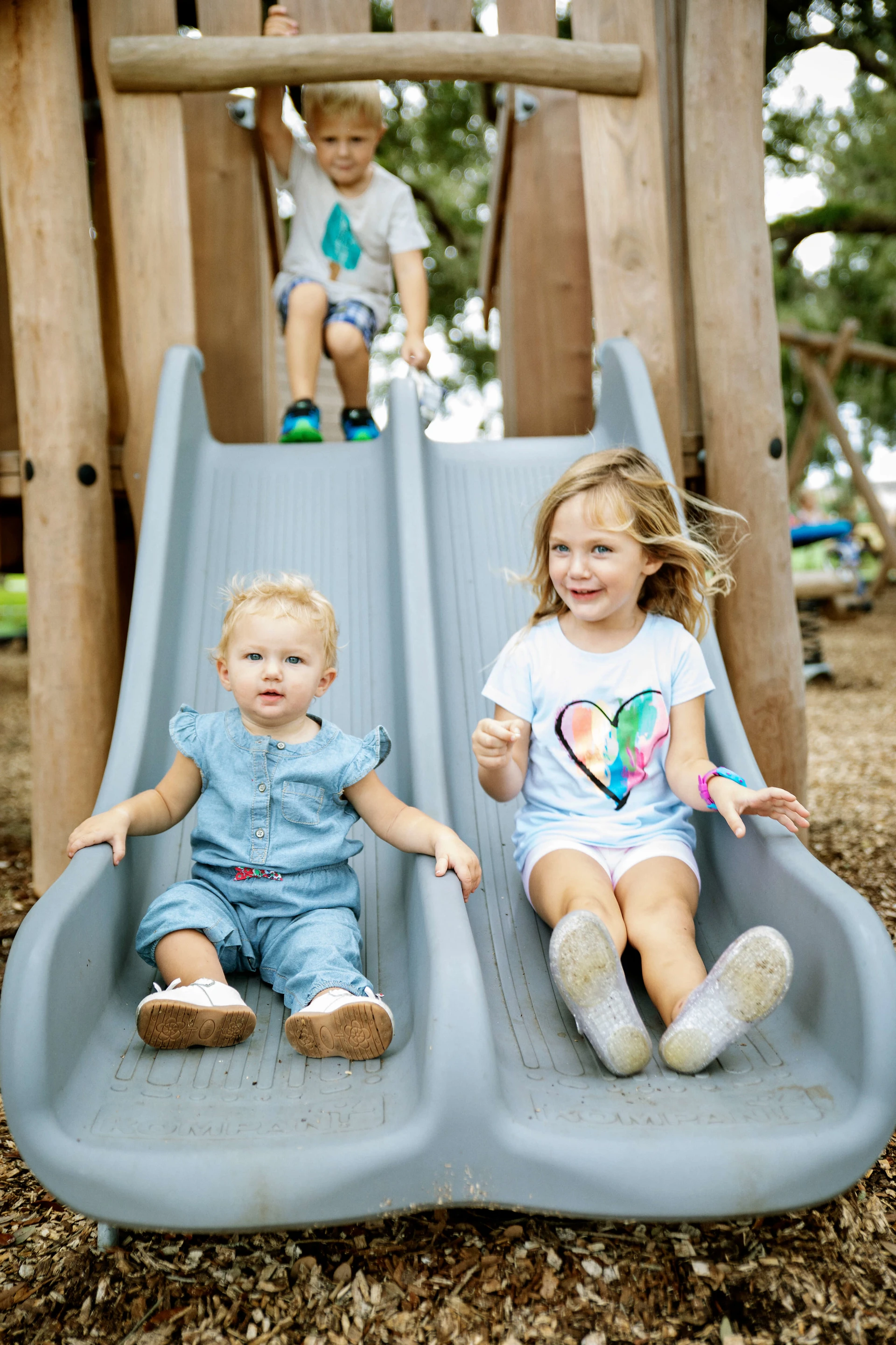 Children sliding down KOMPAN playground equipment