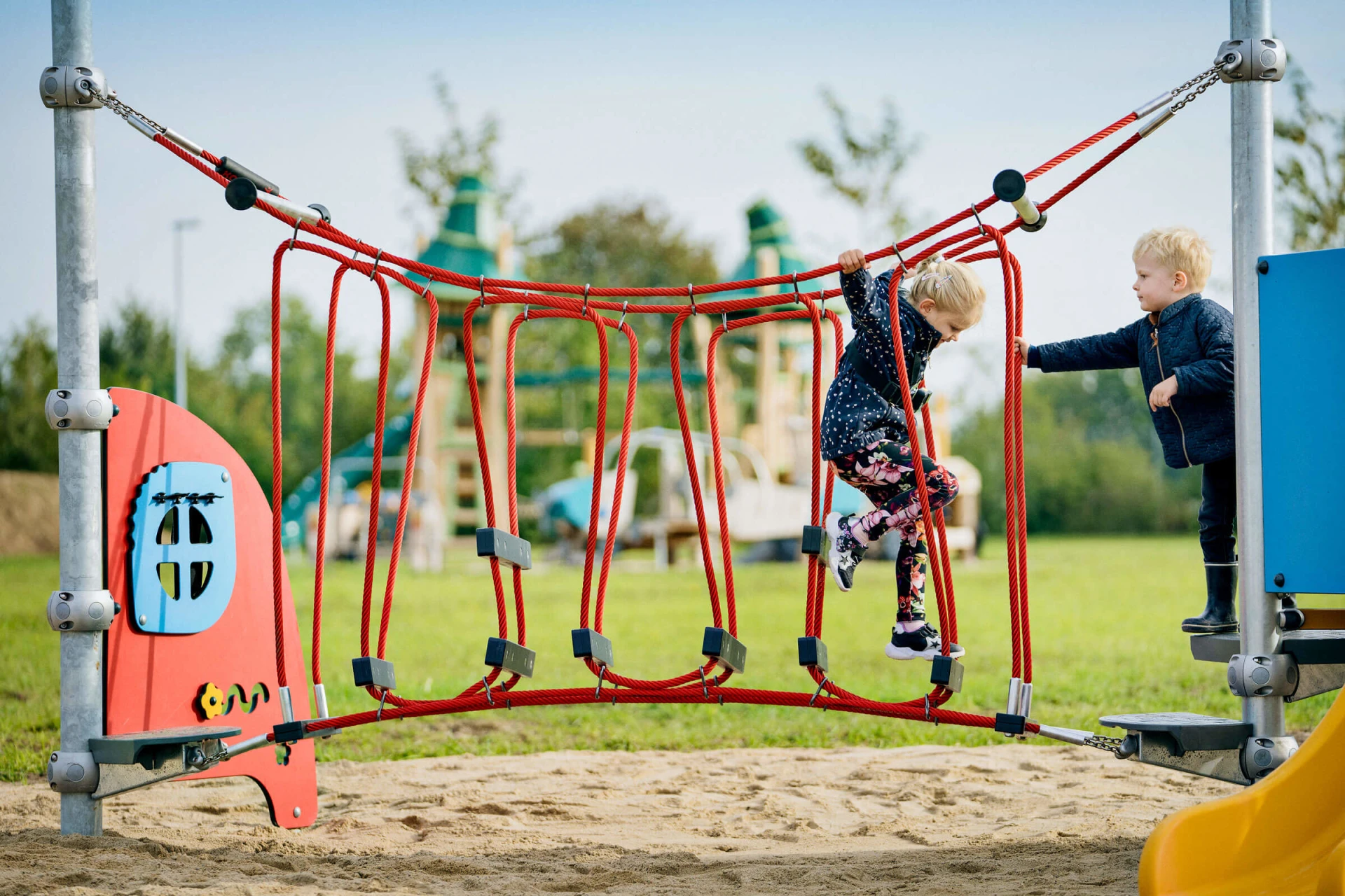 Vorschulkinder spielen auf einem Mini-Spielplatz mit Kletterparcours