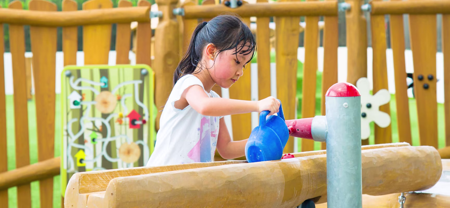 girl playing with sand and water playground equipment at preschool