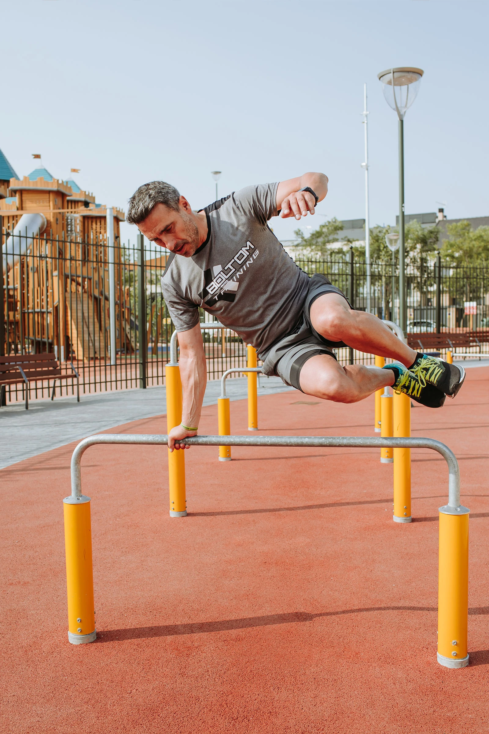man exercising outdoors on outdoor fitness equipment