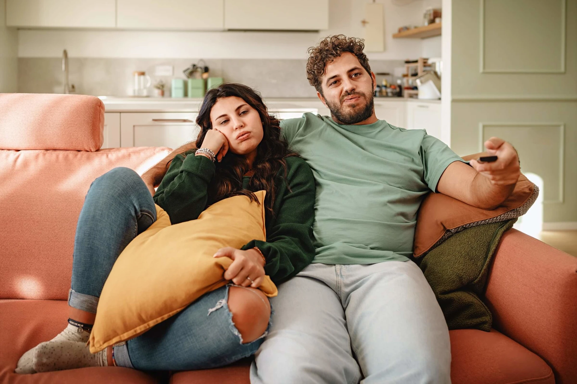 a man and woman sitting on a couch watching tv.