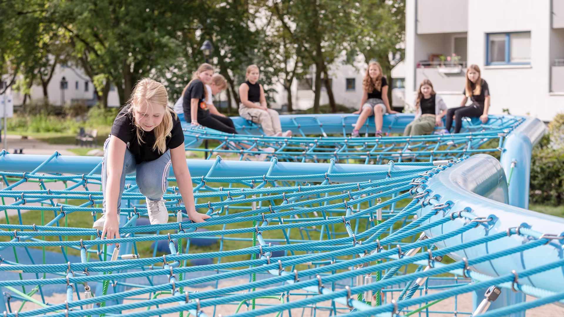 Kinder spielen, klettern und chillen auf einem Corocord-Seilspielgerät Loop im Märkischen Viertel in Berlin