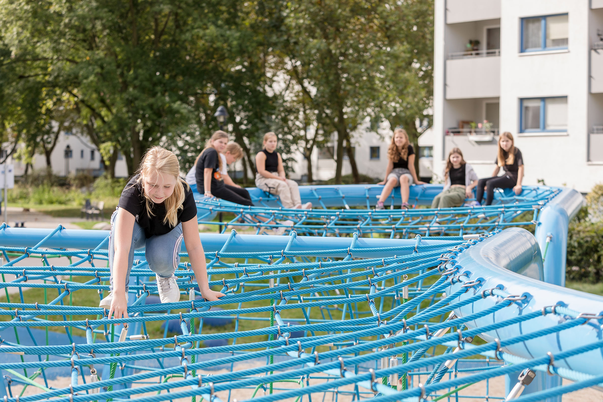 Kinder spielen, klettern und chillen auf einem Corocord-Seilspielgerät Loop im Märkischen Viertel in Berlin