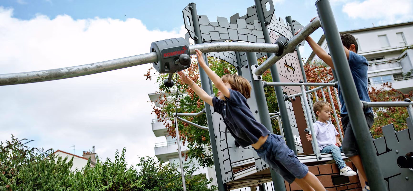 Boys playing on a castle play tower with cableway at Jardin de la ZAC Didot