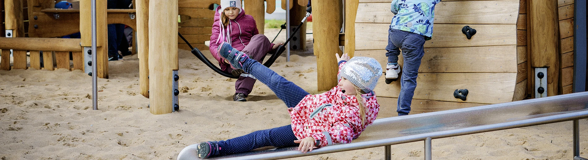 Image of a girl sliding down a playground slide