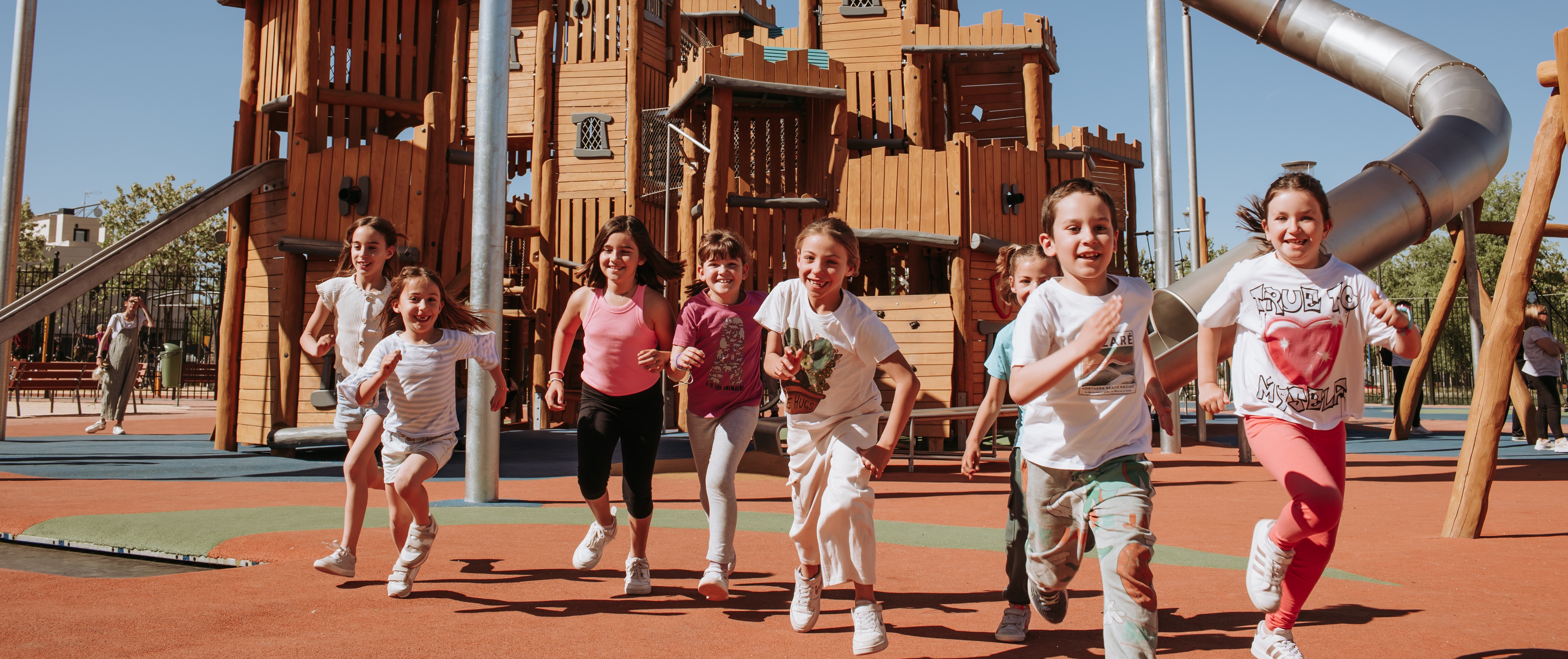 contact KOMPAN top slider image of girl sliding down a playground slide