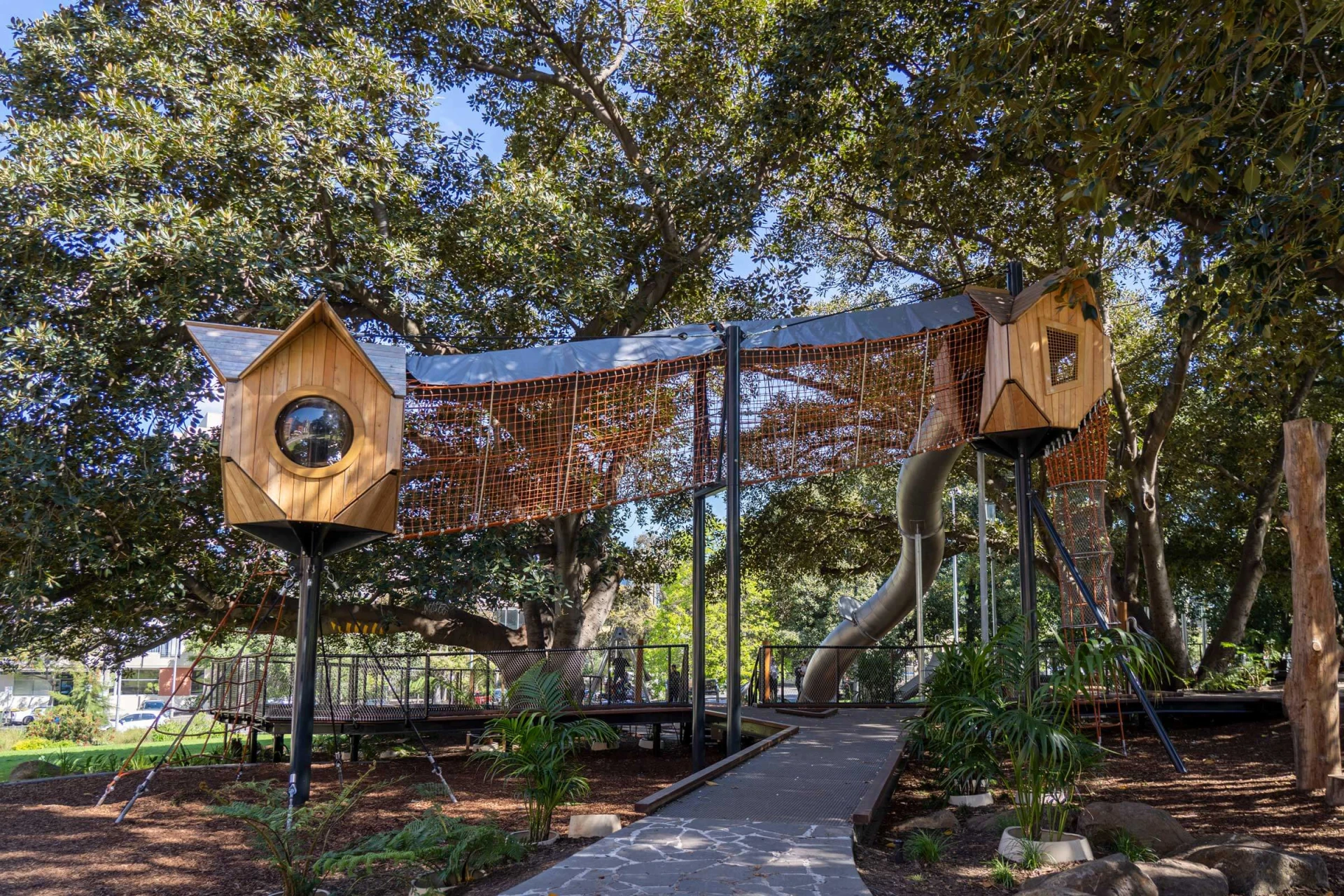 Une tour de jeux en forme de cabane dans les arbres au milieu d'un parc à Melbourne.