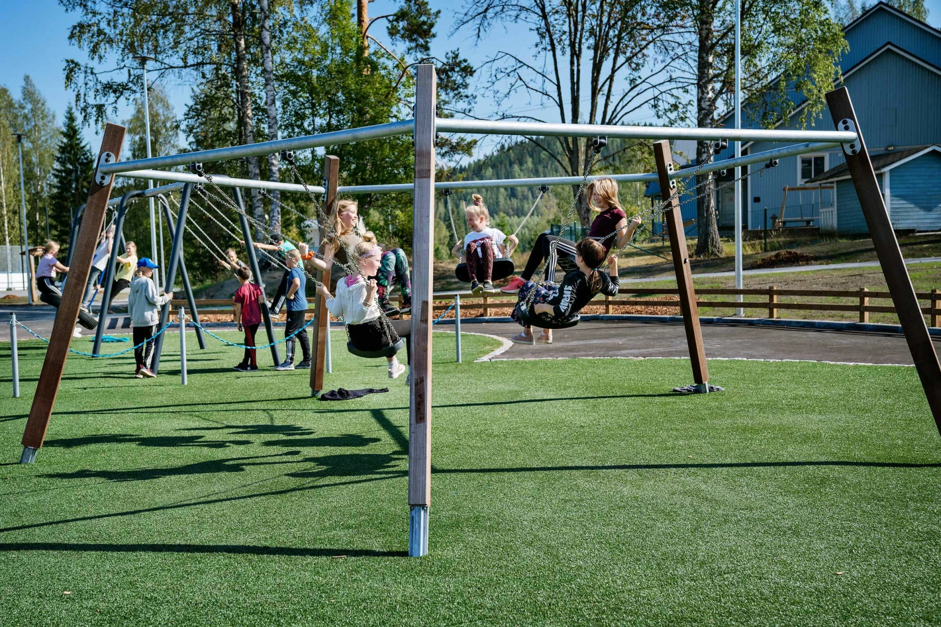 School playground with children swinging on a five way swing