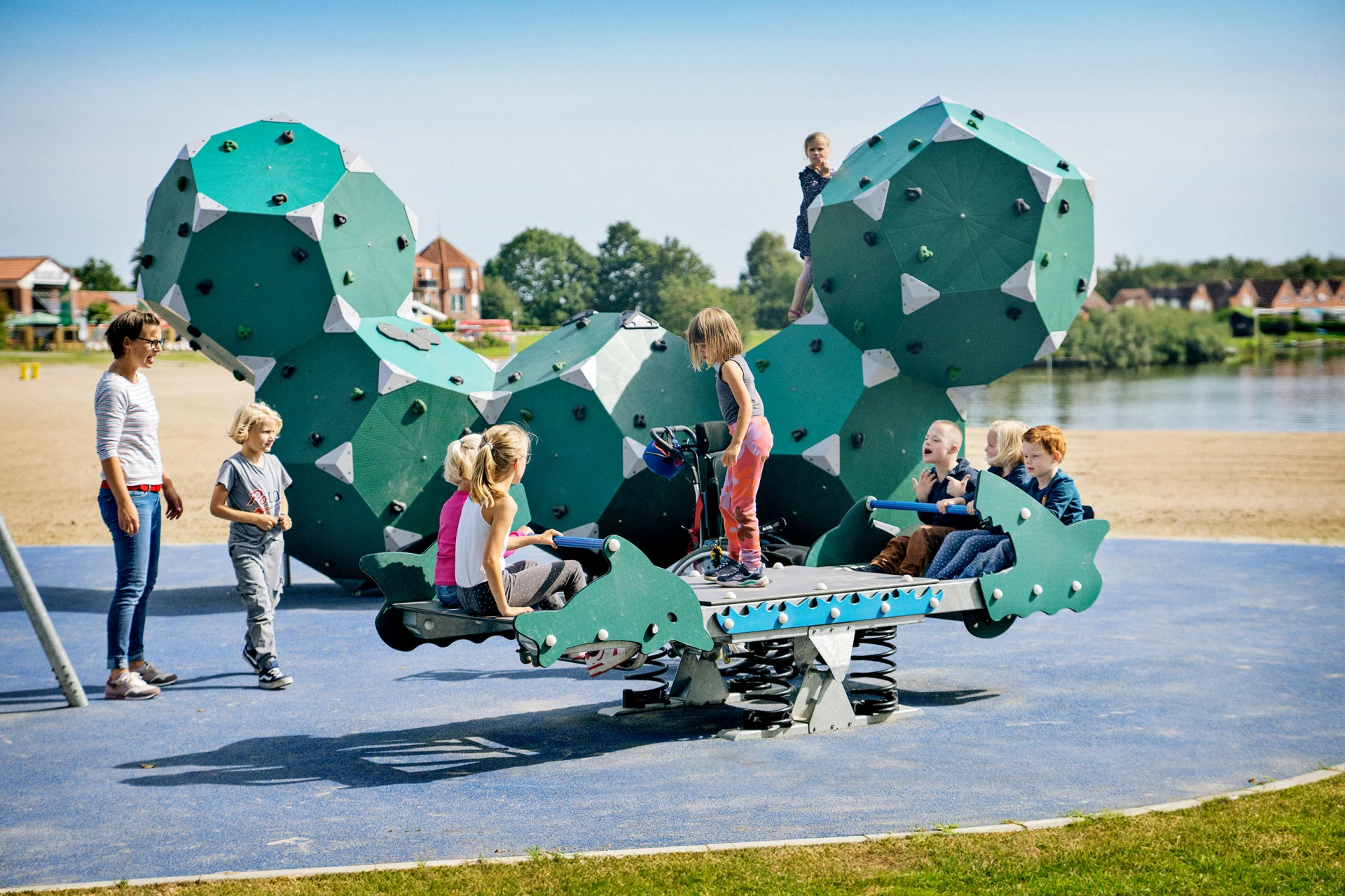 Kinder schwingen auf einer Tampenschaukel auf einem integrativen Spielplatz