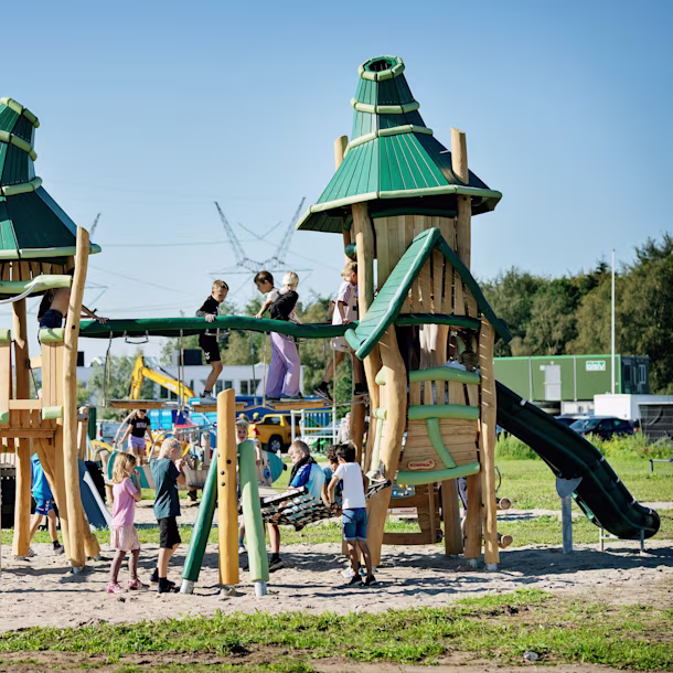 A child playing on a natural wooden playground