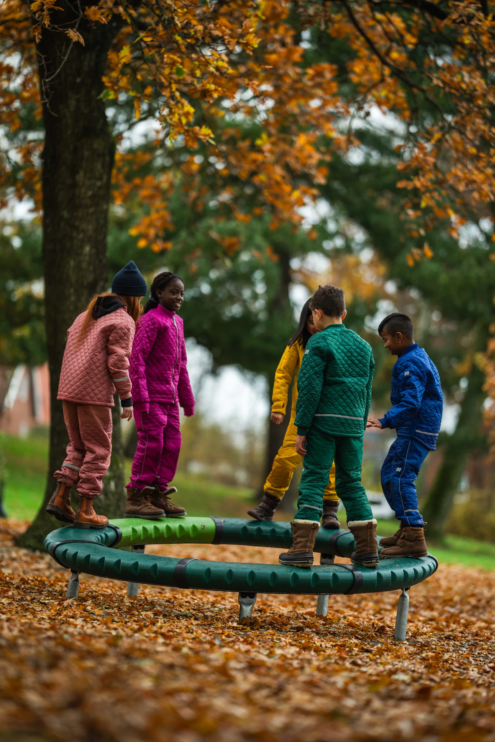 children spinning on a playground carousel