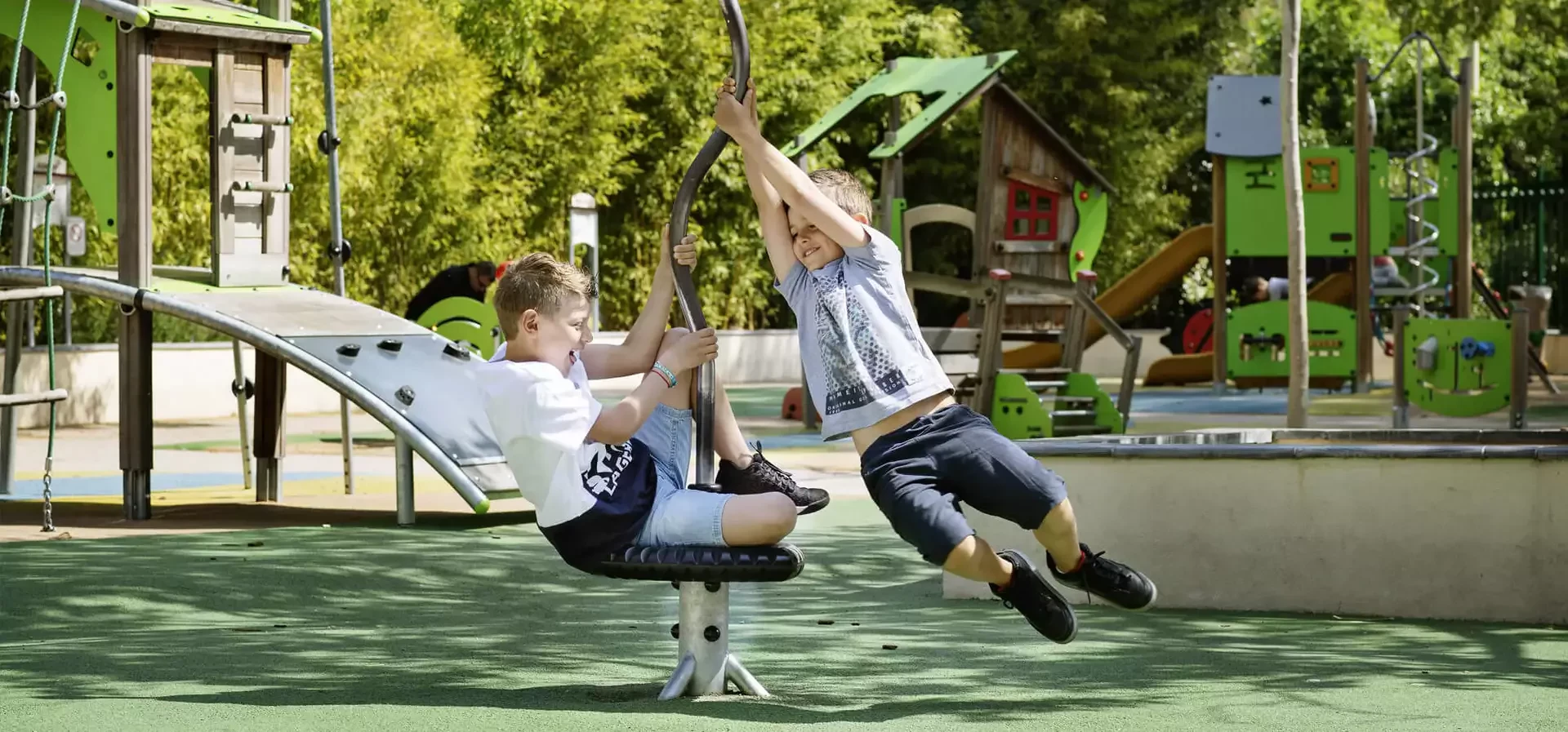 To børn som leger på en Spica spinner på en KOMPAN legeplads.