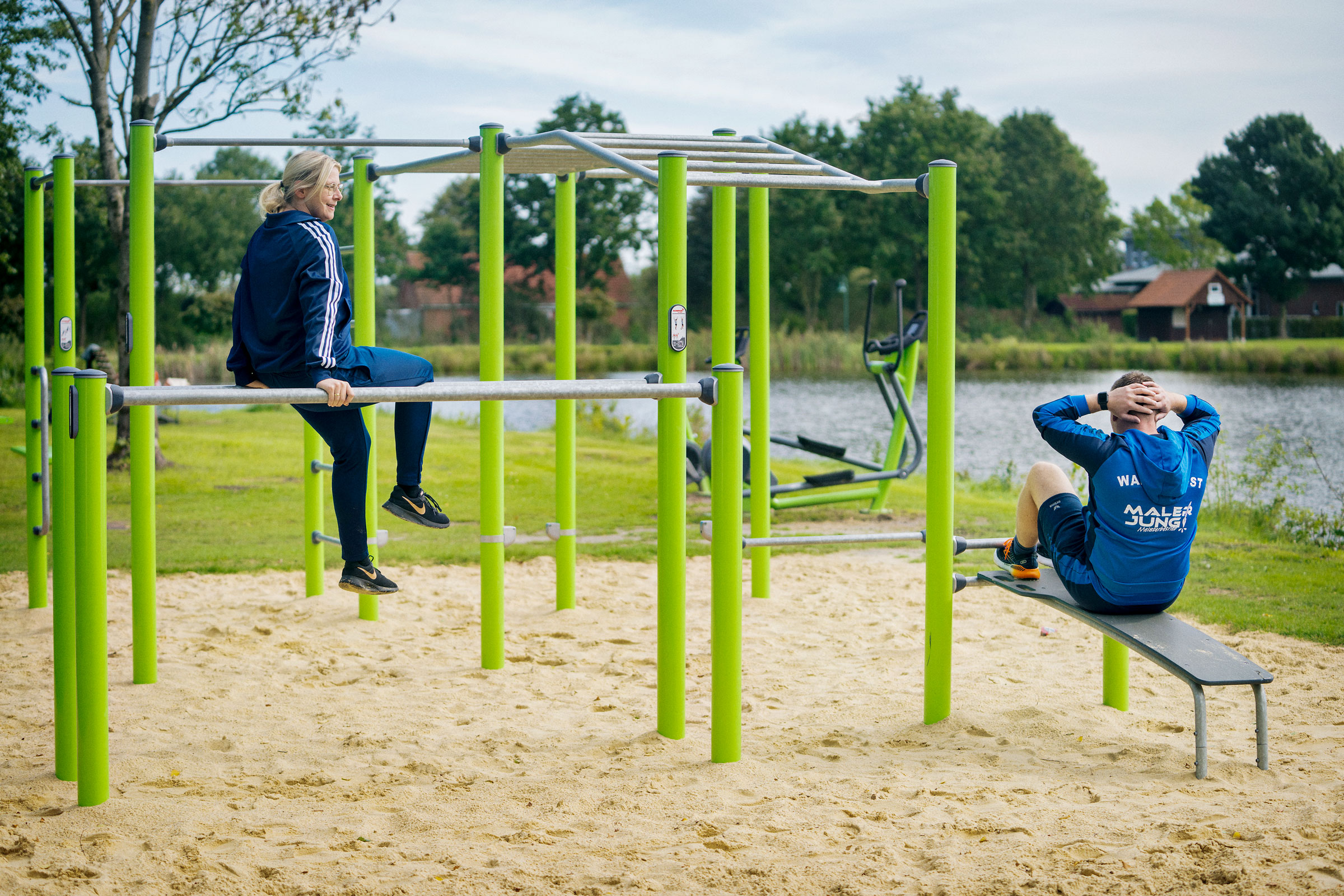 einige Menschen, die in einem Outdoor Calisthenics Gym in einem Park trainieren