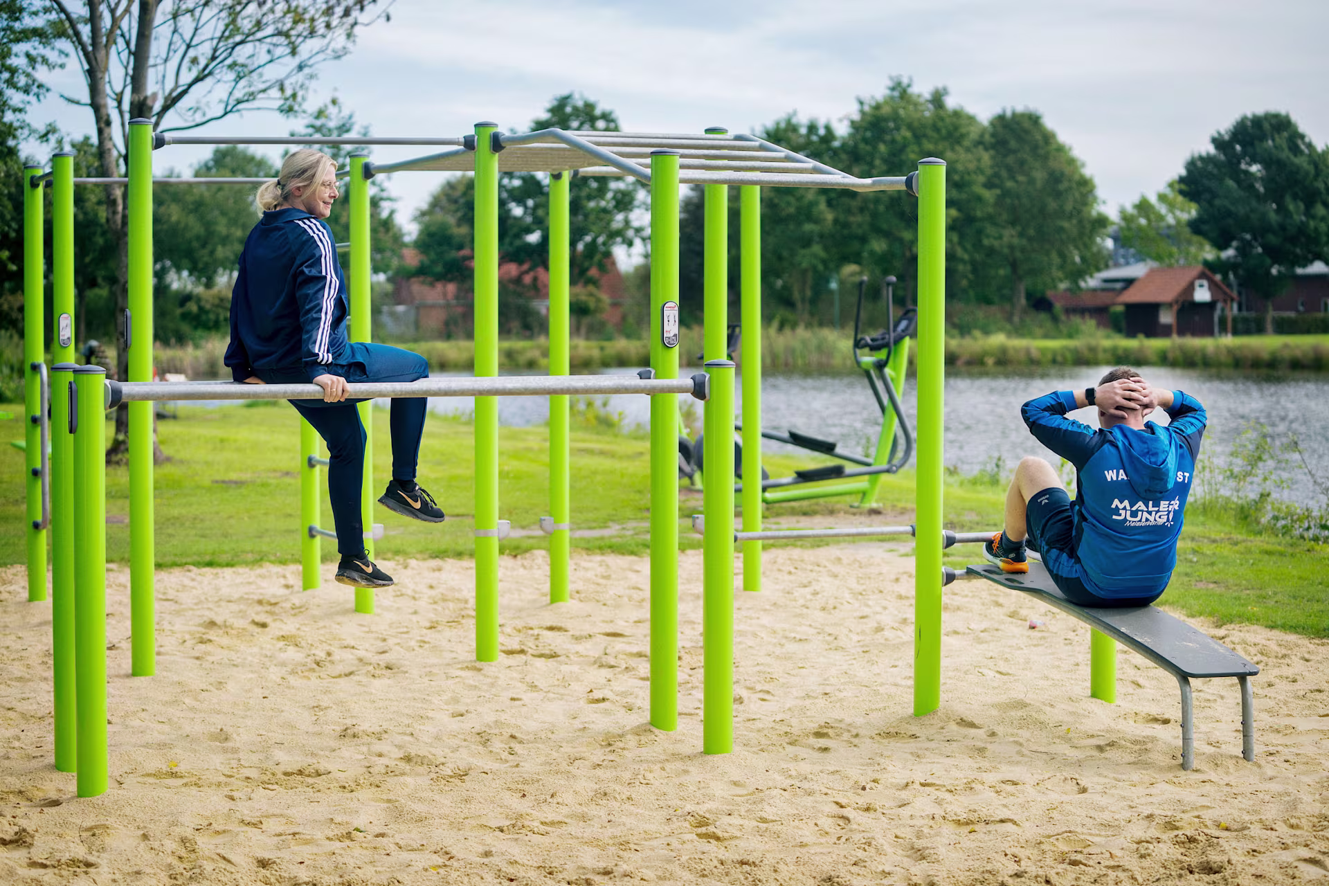 einige Menschen, die in einem Outdoor Calisthenics Gym in einem Park trainieren