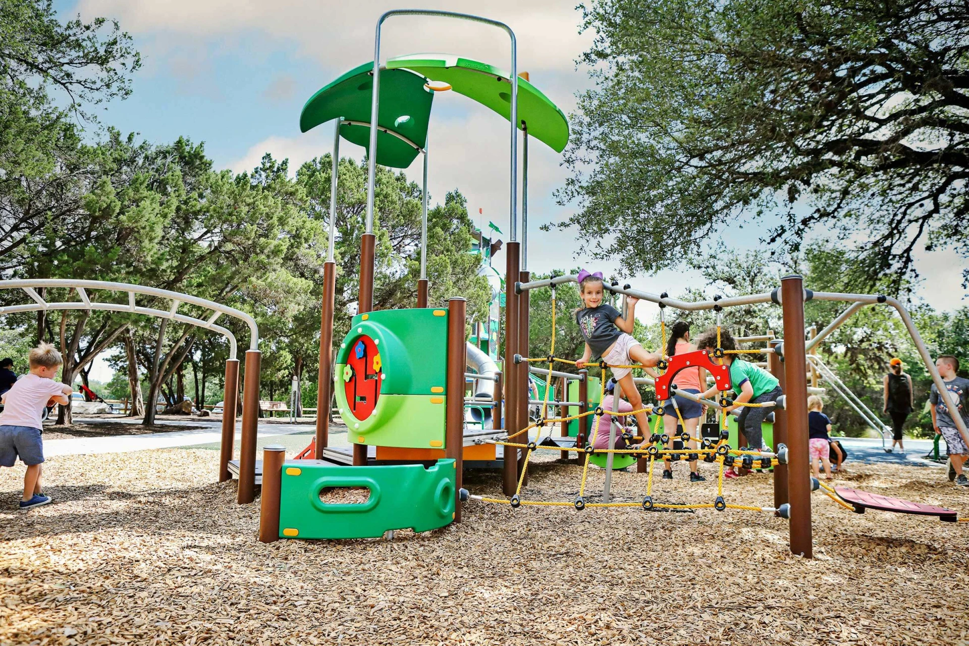 hero image of children playing on preschool playground system in a park