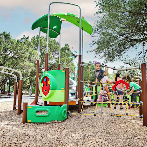 hero image of children playing on preschool playground system in a park