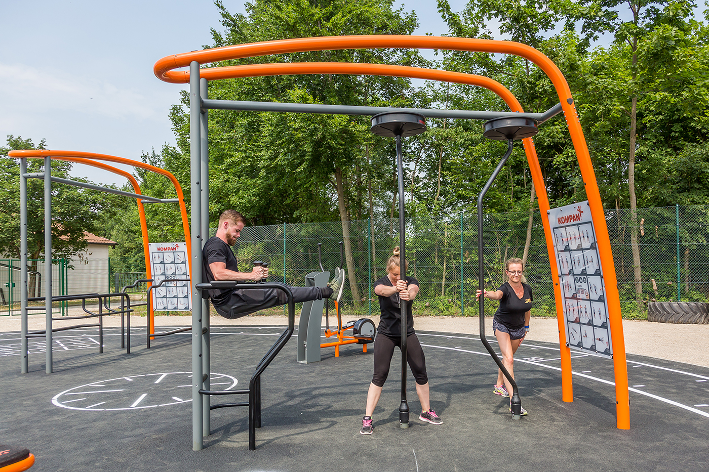 Frau trainiert draußen an einer Trainingsstation
