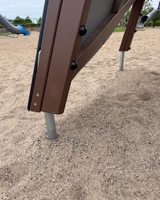 steel footings on wooden playground tower