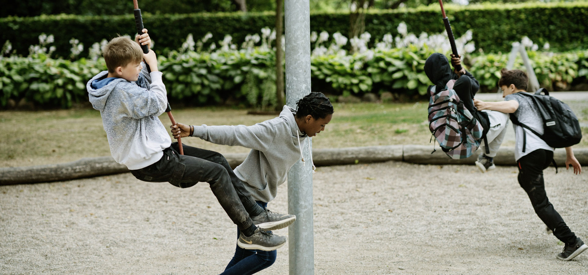 Tweens playing on rotating playground equipment