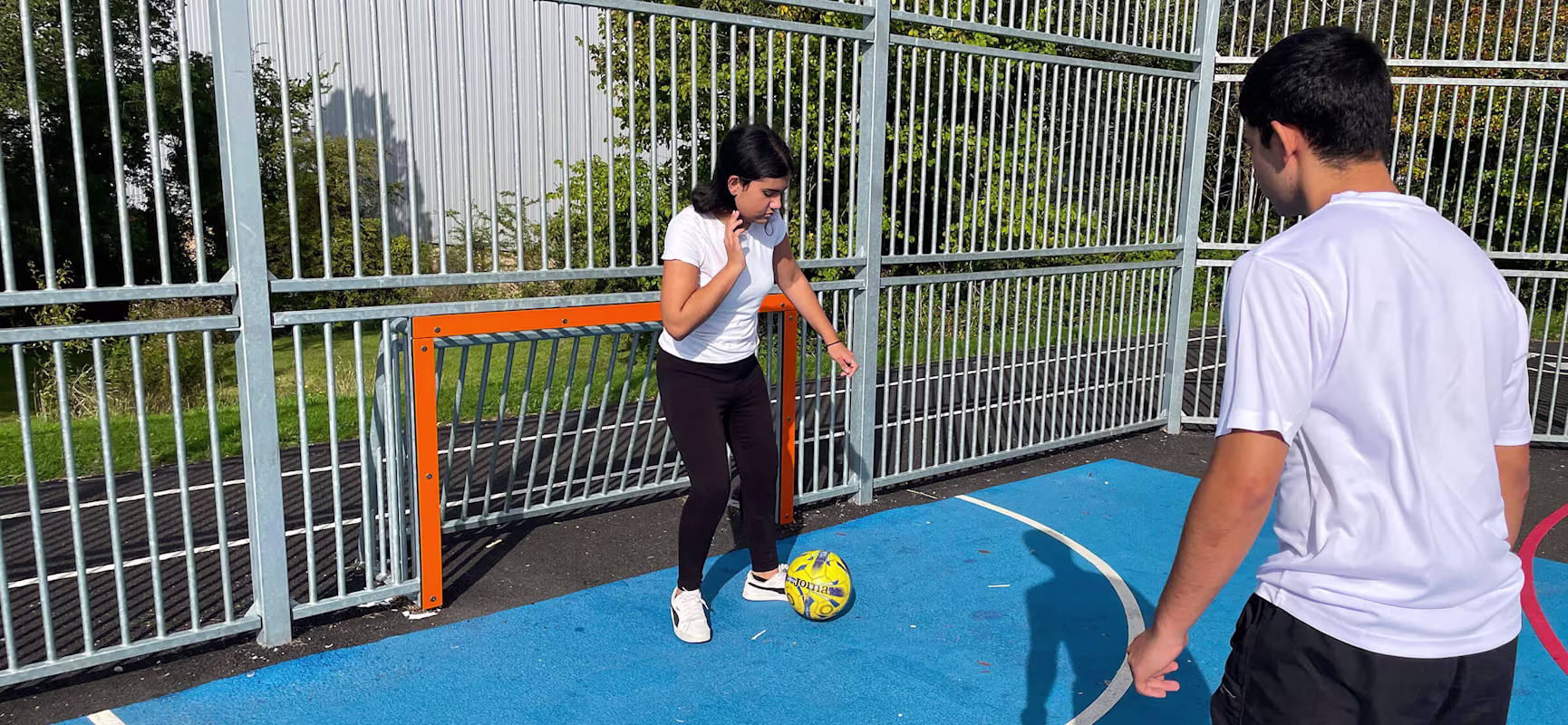 Tweens playing soccer on a multi court