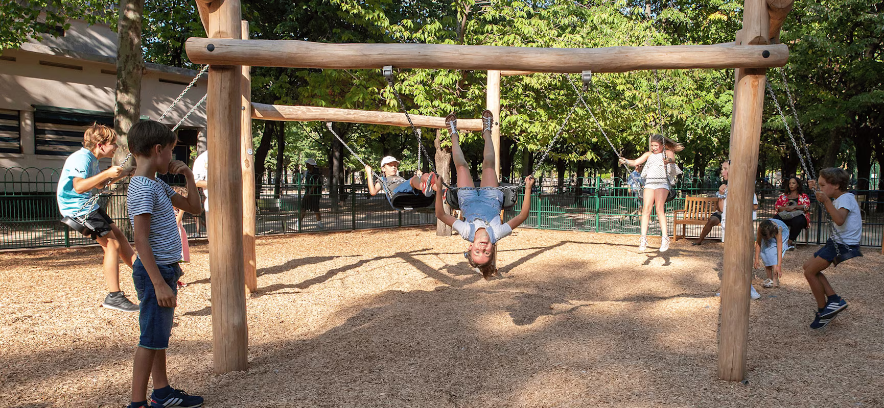children playing on innovative and new type design wooden playground swings hero image