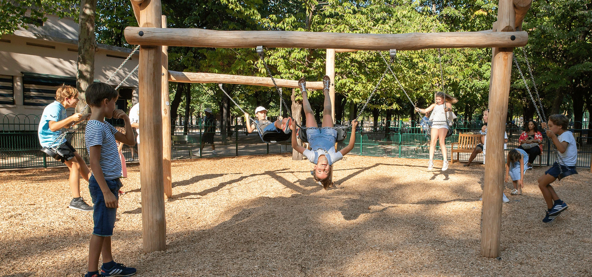 children playing on innovative and new type design wooden playground swings hero image