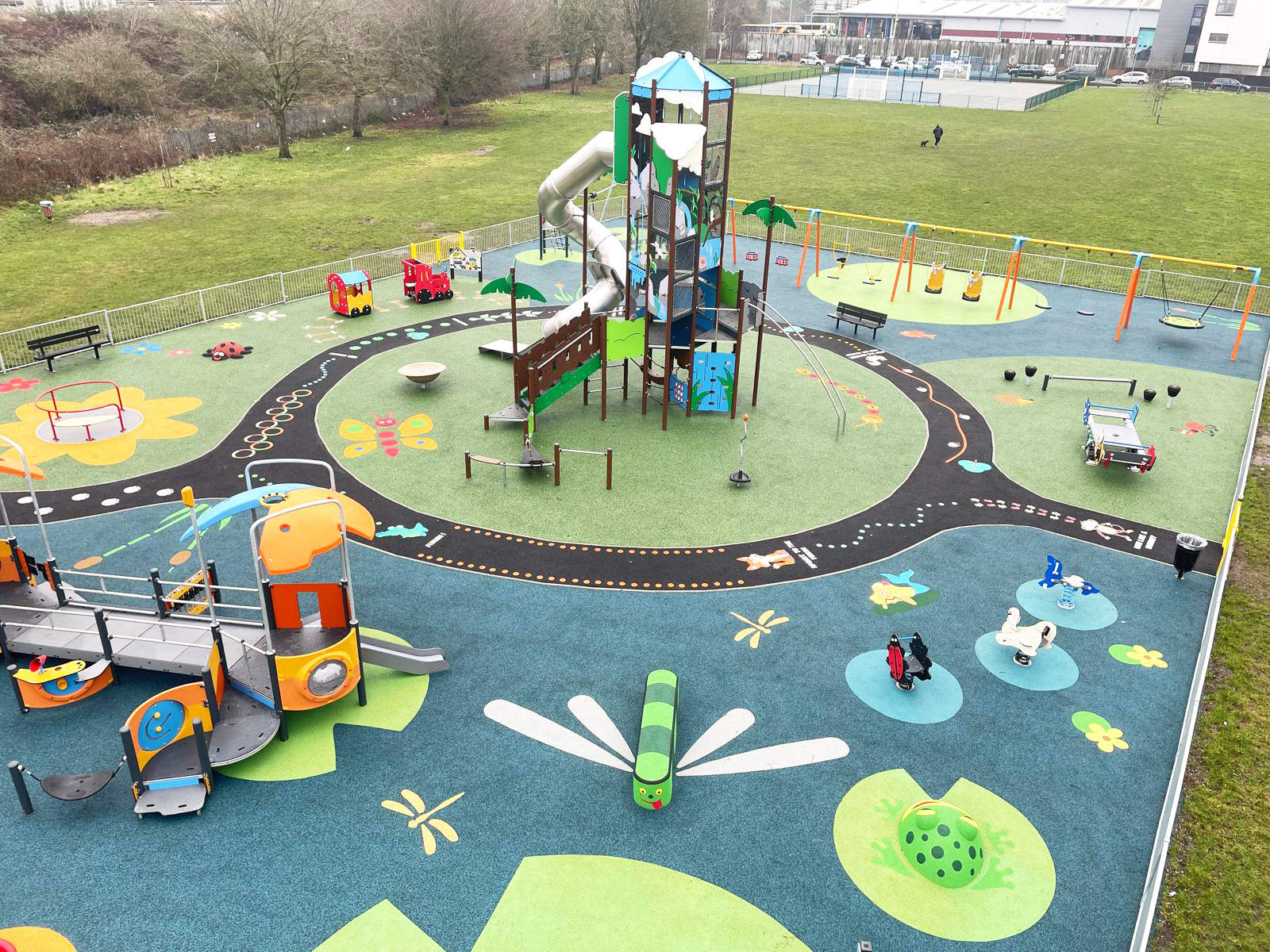 a colourful playground with a giant play structure and toddler play equipment