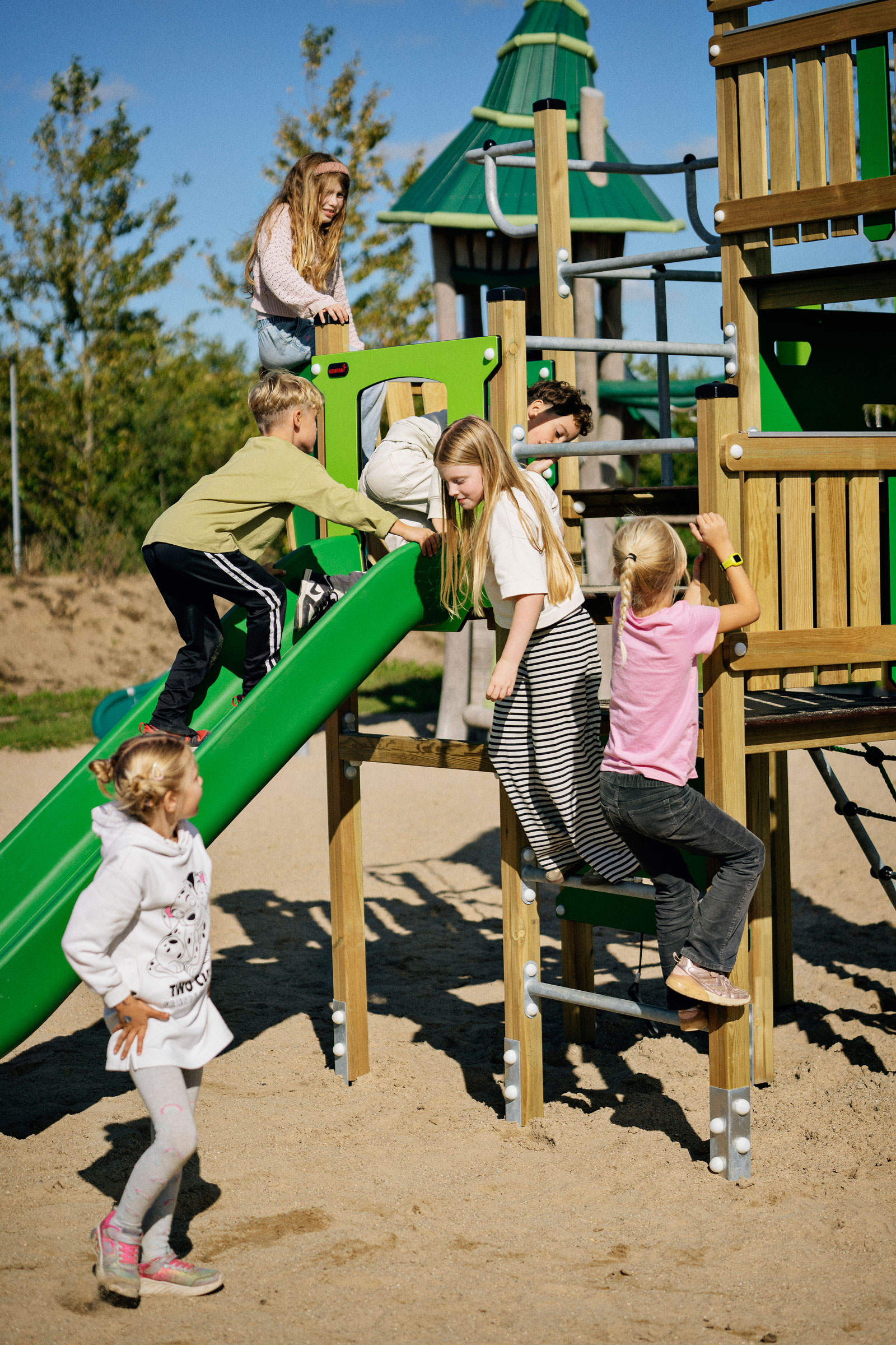 children playing on a northland playground structure with slide