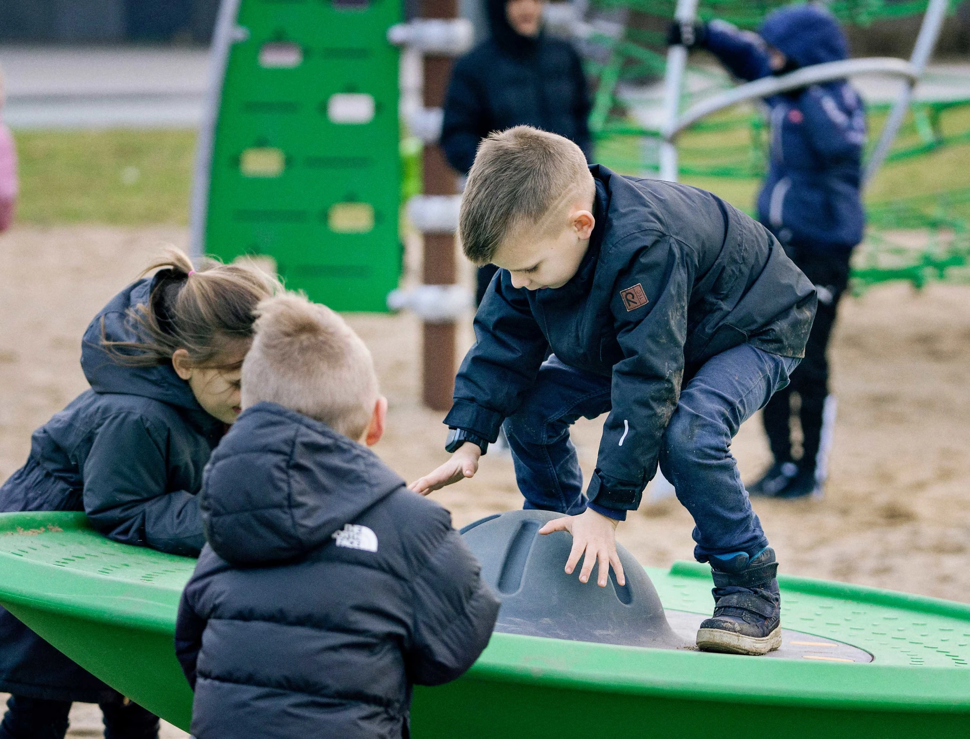 Kids working together to spin around on the Spinner Disc