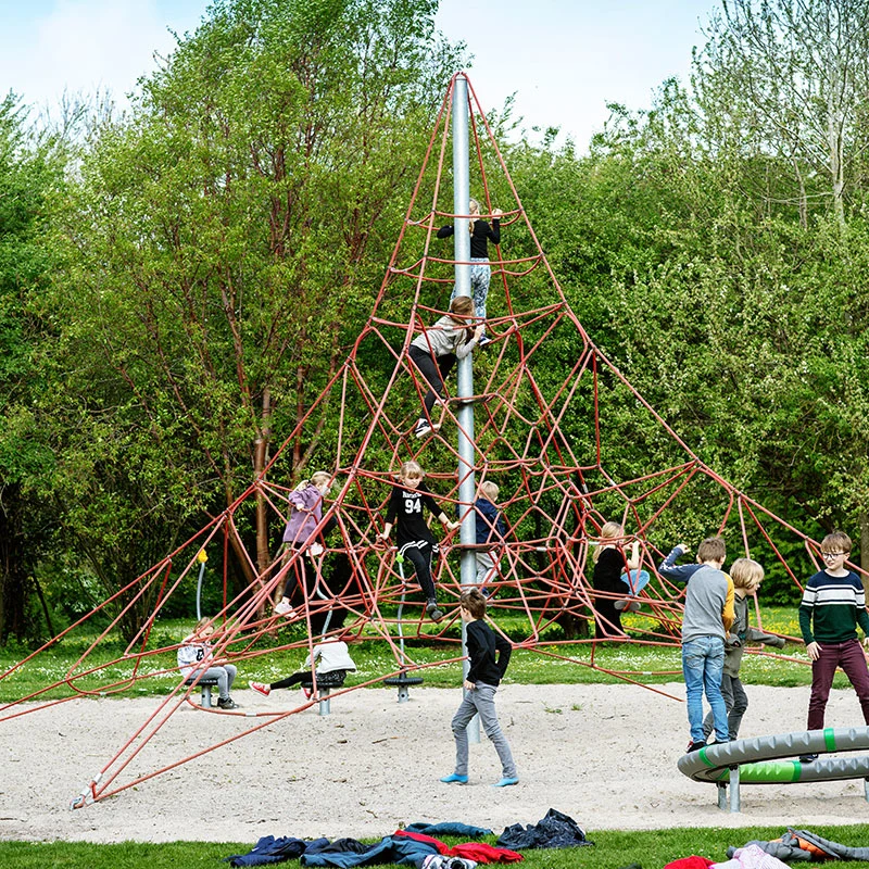Kinder klettern eine Spielplatz-Kletterpyramide hoch