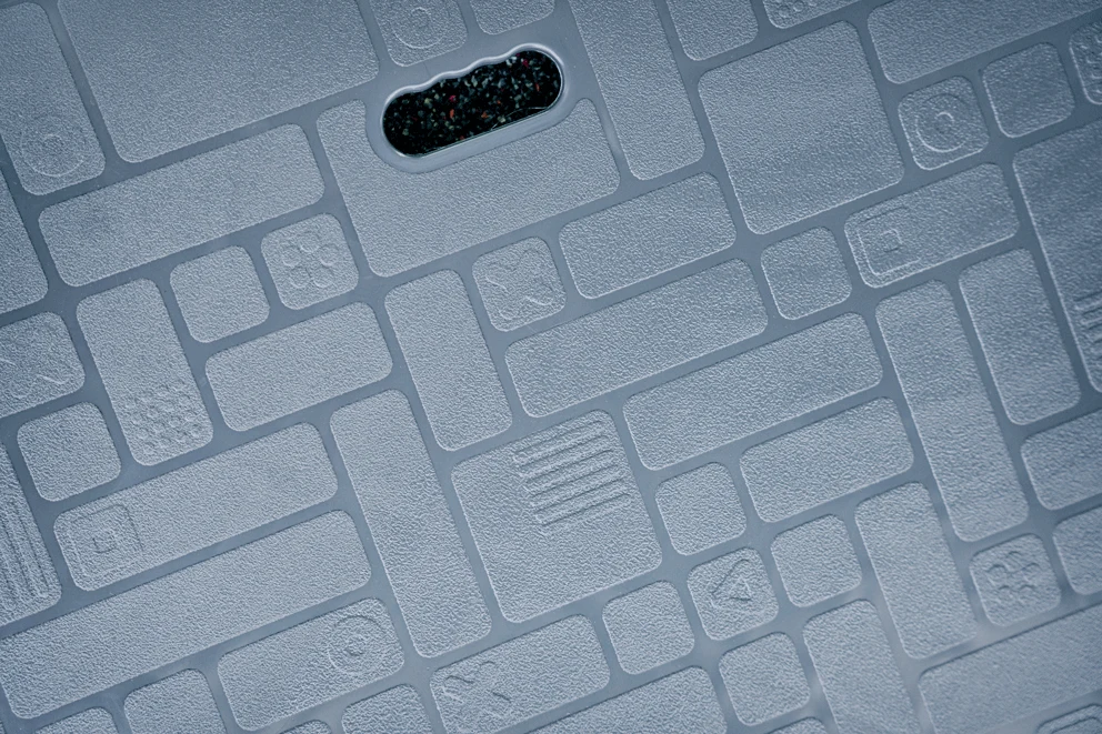 närbild av ett grått golv av återvunnen plast på en lekställning