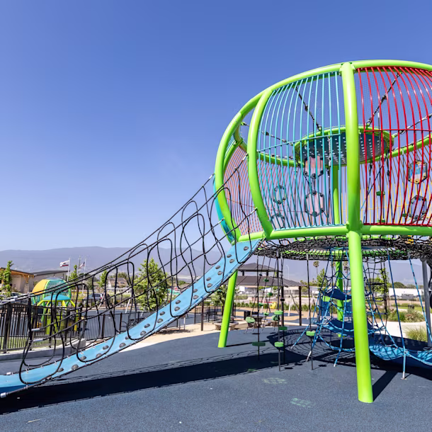 Colorful custom rope climbing structure at Orchard Lane Park in Soledad, California