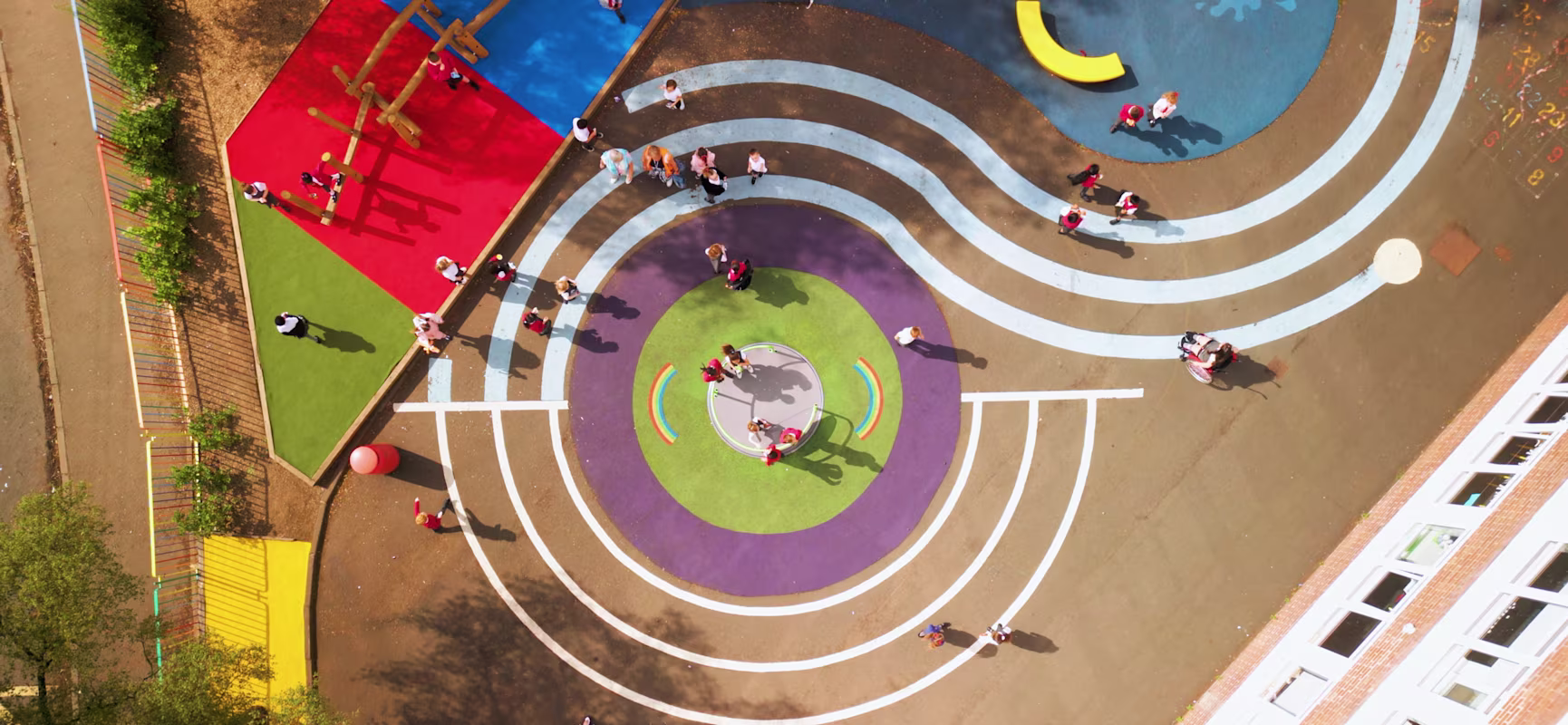 An aerial view of a children's school playground with wet pour surfacing