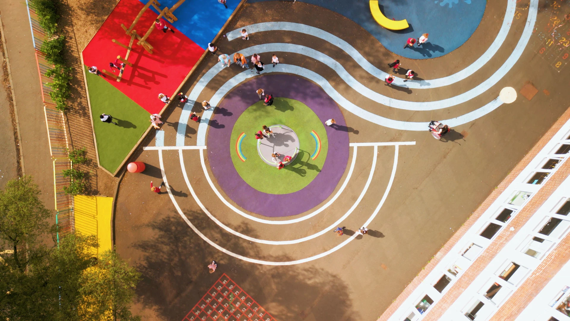 An aerial view of a children's school playground with wet pour surfacing
