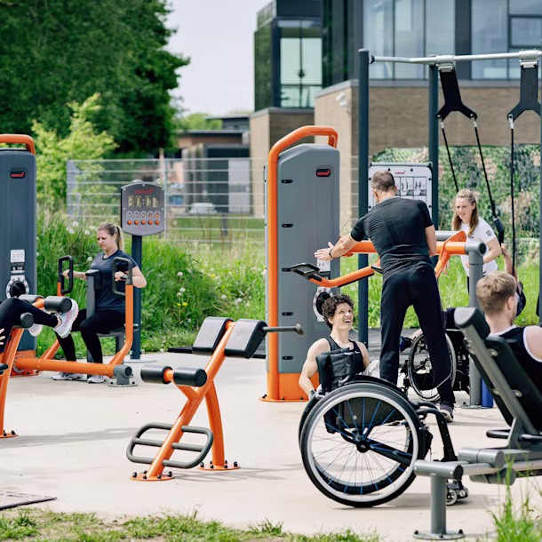En gruppe mennesker som bruker treningsutstyr i en park.