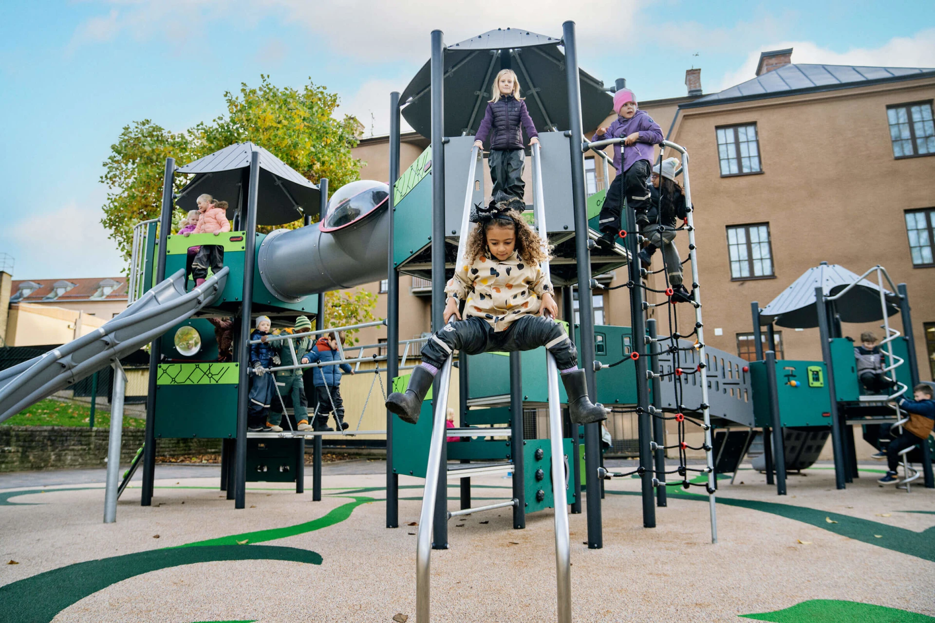 school-age children play on MOMENTS™ play tower on playground in Skara