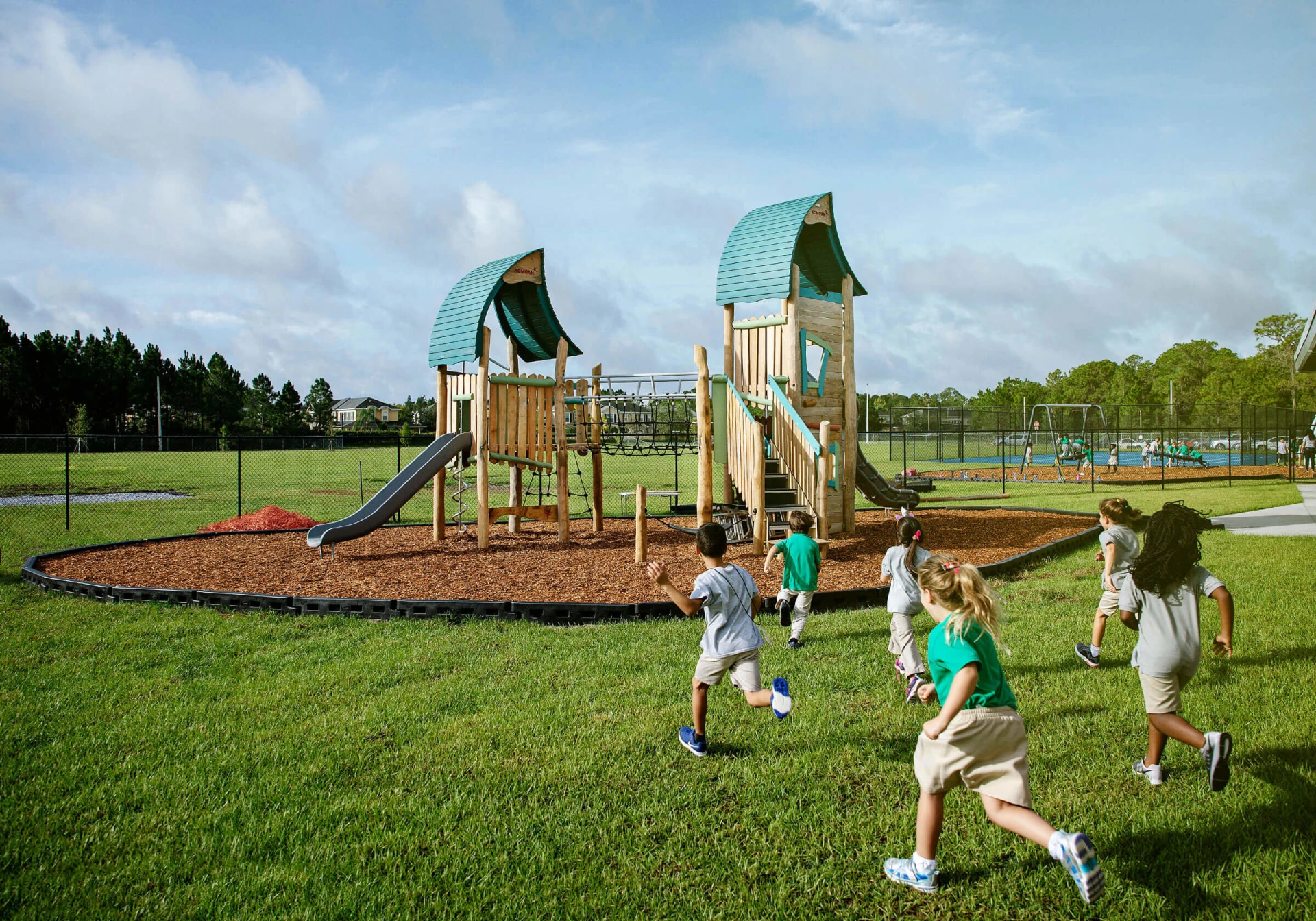Schüler der North Tampa Christian Academy rennen zu Spielturm aus Holz